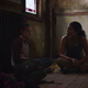 Ellie and Marlene sit on the floor in a scene from HBO's The Last of Us.